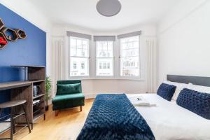 uma sala de estar com uma cama e uma cadeira em Cannon Street Studios em Londres