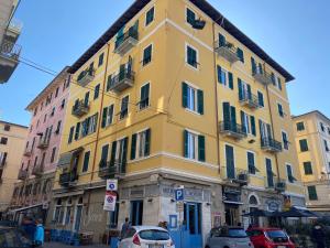 a yellow building with cars parked in front of it at 54 ROSSELLI ROOMS in La Spezia