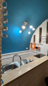 een keuken met een wastafel en een blauwe muur bij Tivoli Casa Belvedere in Tivoli