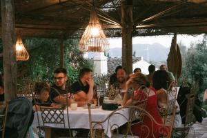 um grupo de pessoas sentadas numa mesa num restaurante em Hotel Rural Alqueria de los lentos em Nigüelas
