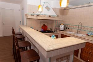 eine Küche mit einer Theke mit Stühlen und einer Arbeitsplatte in der Unterkunft Villa Seven Palms in Isola delle Femmine