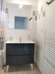 bagno con lavandino nero e specchio di BiscaOcéan a Biscarrosse-Plage