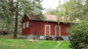 a red house with a white chair in front of it at Rauma Room's House 9 200m2 in Rauma