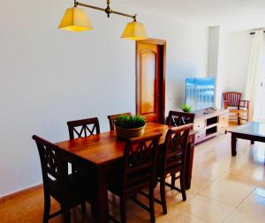 una sala da pranzo con tavolo e sedie in legno di Brisa Del Mar Fuerteventura a Puerto del Rosario