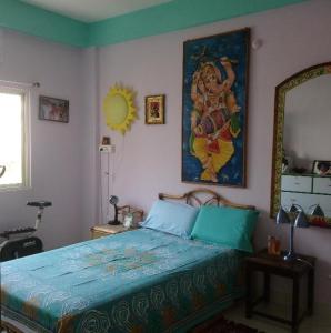 a bedroom with a bed and a painting on the wall at Casa di Mara in Puttaparthi