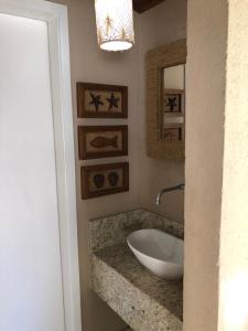 uma casa de banho com um lavatório e um espelho em Casa em Arraial d’Ajuda em Porto Seguro