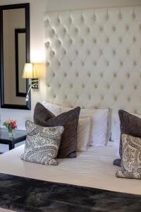 a large white bed with pillows on it at Rawdons Hotel & Brewery in Nottingham Road