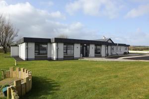 a white building with a black roof at Causeway guest accommodation in Bushmills