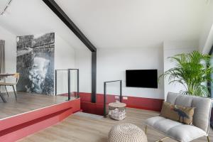 a living room with a chair and a tv at Waterlinie Lodges in Utrecht