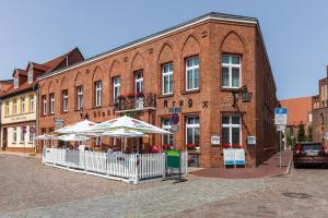 a brick building with two umbrellas in front of it at Hotel Stadtkrug in Parchim