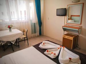 een kamer met 2 bedden, een tafel en een spiegel bij Uyum Hotel in Pamukkale
