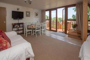 a living room with a white couch and a dining table at Chalet 98 in Deal