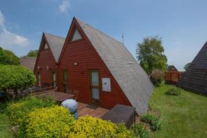 a red house with a gambrel roof at Chalet 98 in Deal