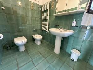 ein grünes Bad mit einem Waschbecken und einem WC in der Unterkunft Villa Chris in Taormina