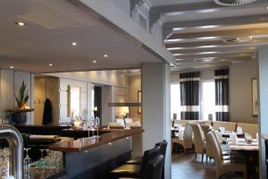 Un restaurante con barra, mesas y sillas. en Hotel-Restaurant Große-Wilde, en Bottrop