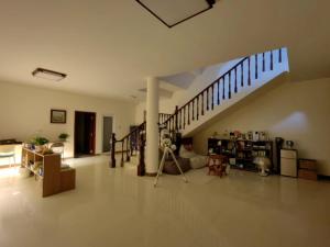 a living room with a staircase in a house at Valley Oasis Villa in Enshi