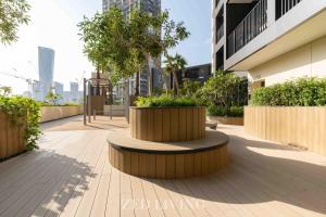 a sidewalk with a bench and trees and buildings at Zed Living - Ahad Residences - Tranquil 1 BR in Business Bay in Dubai