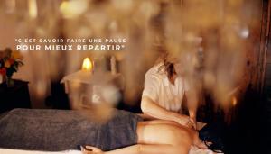 a woman sitting on a bed in a room at La Ferme de Beauté in Chateauroux-les-Alpes