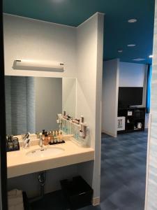 ein Badezimmer mit einem Waschbecken und einem großen Spiegel in der Unterkunft Ocean Hotel adult only - former Kagoshima Intelligence in Kagoshima