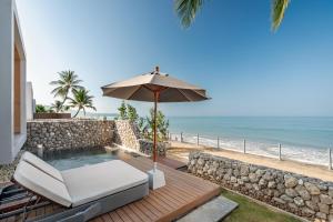 een patio met een parasol, een stoel en een zwembad bij Casa De La Flora - SHA Extra Plus in Khao Lak