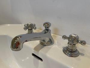 a bathroom sink with a faucet and two knobs at Strandgut in Rostock