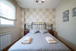 1 dormitorio con 1 cama con 2 toallas en Puente de Hierro, en Zamora