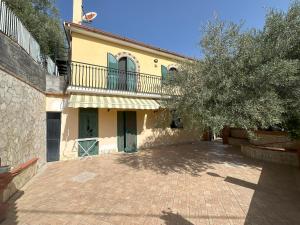 ein Haus mit einem Balkon und einer Ziegelsteinfahrt in der Unterkunft Villa Chris in Taormina