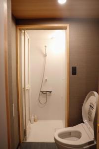 uma casa de banho com um chuveiro, um WC e um lavatório. em 千本南大阪で日本の伝統的な文化を感じられる雰囲気 em Osaka