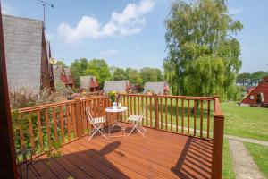 a wooden deck with a table and chairs on it at Chalet 99 in Deal