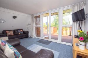 a living room with a couch and a television at Chalet 99 in Deal