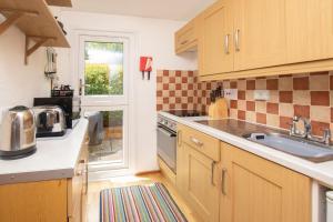 a kitchen with wooden cabinets and a sink and a window at Chalet 99 in Deal