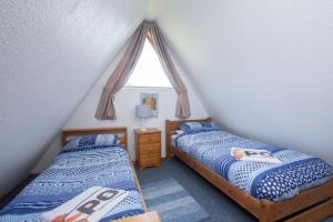two twin beds in a room with a window at Chalet 99 in Deal