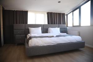 a large bed in a bedroom with windows at ARDOS PARK HOTEL in Ankara