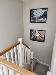 a room with a staircase with a tv on the wall at Private room in townhouse near Heathrow & Windsor in Burnham