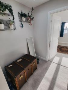 ein Zimmer mit einem Kofferraum auf dem Boden neben einer Tür in der Unterkunft Private room in townhouse near Heathrow & Windsor in Burnham