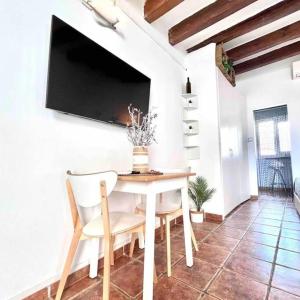 uma sala de jantar com uma mesa e uma televisão na parede em Taulat House l Mediterranean Loft l BEACH l ChillOut l Self CheckIn by TURYHOST em Barcelona