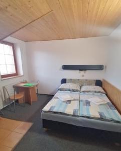a bedroom with a bed and a table in it at Ranc pod Rejvizem in Zlaté Hory