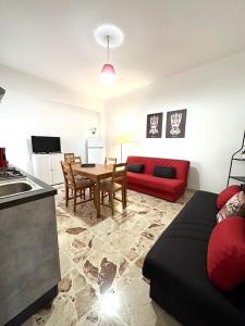 uma sala de estar com um sofá vermelho e uma mesa em Il Rifugio Storico in Piazza em Augusta