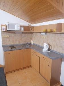 a small kitchen with a sink and a microwave at Ranc pod Rejvizem in Zlaté Hory