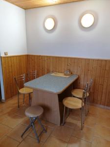 a room with a counter with chairs and a table at Ranc pod Rejvizem in Zlaté Hory