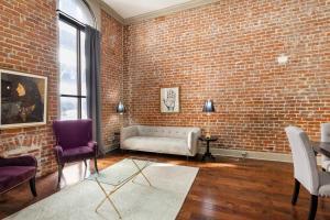 uma sala de estar com uma parede de tijolos e um sofá em Chuck's Place em Nova Orleans
