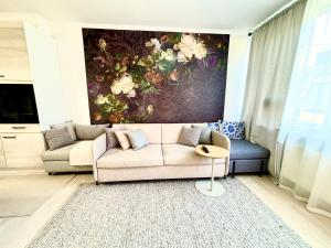 ein Wohnzimmer mit einem Sofa und einem Gemälde an der Wand in der Unterkunft Luxurious Boutique Apartment, inner city, next to Canals and Metro station in Kopenhagen