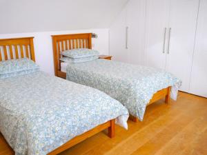 dwa łóżka siedzące obok siebie w pokoju w obiekcie The Longhouse w mieście Castle Douglas