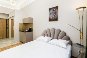 a bedroom with a large white bed with a large headboard at Jacuzzi Berka Apartamenty in Krakow