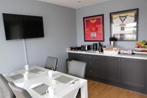 a dining room with a table with chairs and a television at Causeway B&B in Bushmills