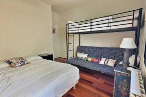 een slaapkamer met een stapelbed en een bank bij Sublime appartement face à la mer in Valras-Plage