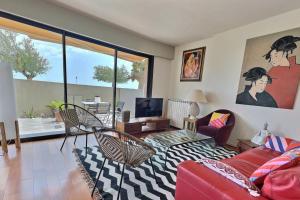 uma sala de estar com um sofá vermelho e uma televisão em Sublime appartement face à la mer em Valras-Plage