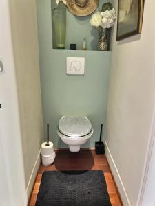 een badkamer met een toilet en een zwart tapijt bij Sublime appartement face à la mer in Valras-Plage