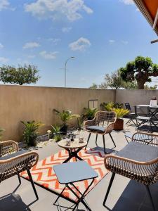 een patio met tafels en stoelen en een hek bij Sublime appartement face à la mer in Valras-Plage