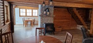 a dining room with a fireplace in a log cabin at Srubová Chata Tis in Heřmanovice